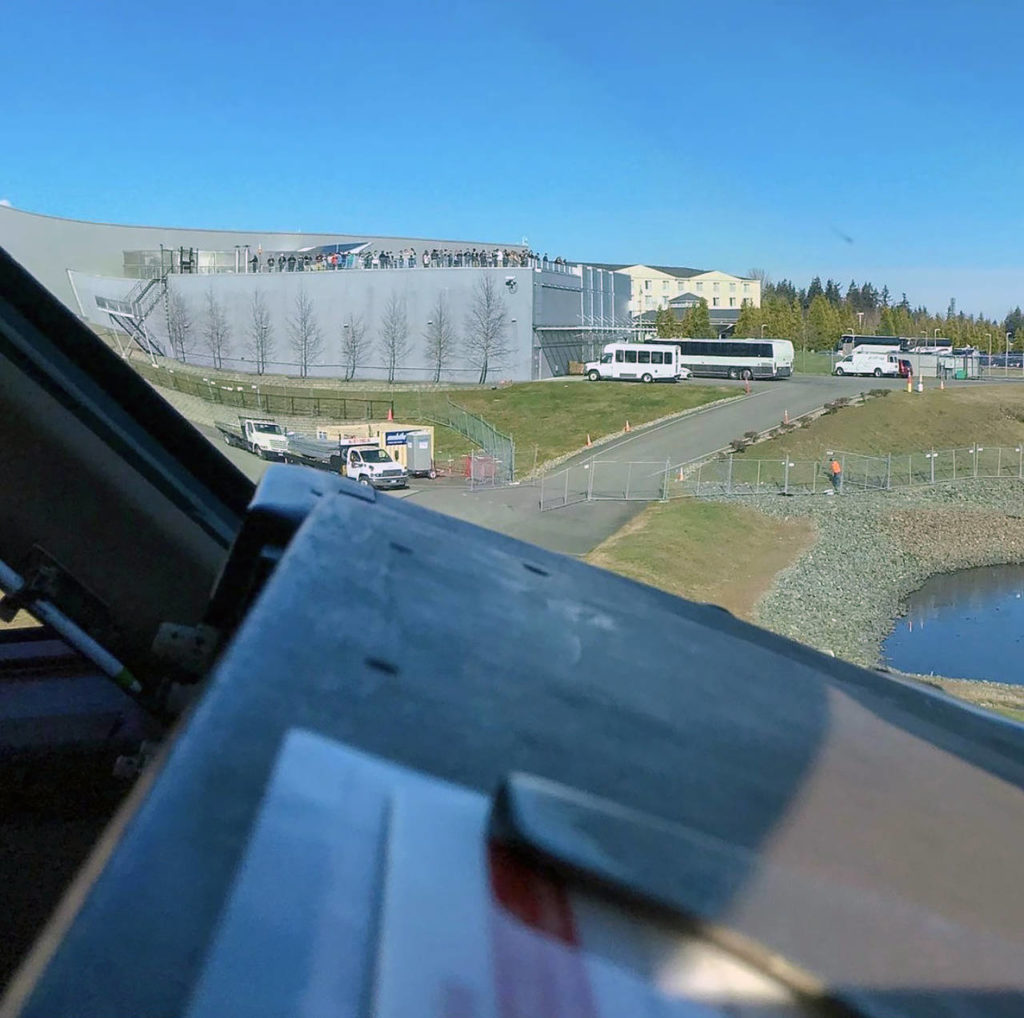 A pilot’s eye view from the cockpit of a Boeing 747: Visitors atop the observation deck at the Boeing Future of Flight at Paine Field in Everett. (Kelsey Hughes) 
