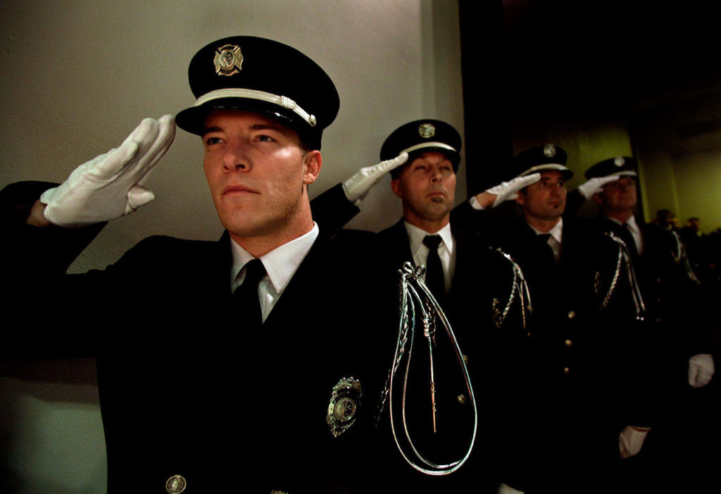 Everett firefighters salute at a Gary Parks memorial ceremony at Everett Community College in 2012. (Michael O’Leary / Herald file)
