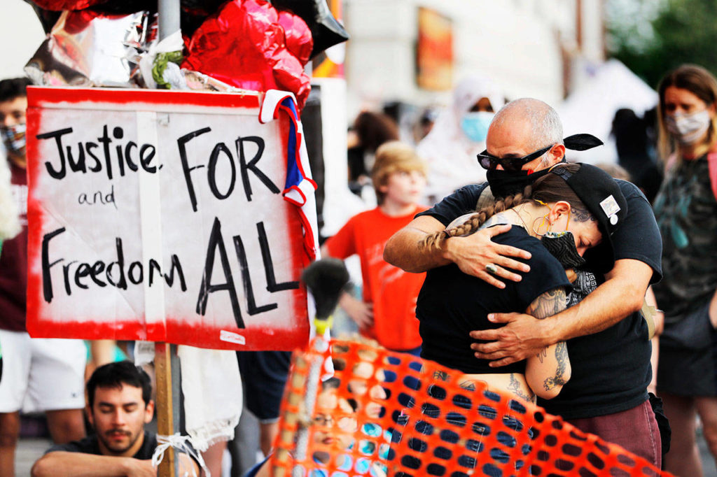 People gather at the site, June 3, where George Floyd died in Minneapolis. Minnesota Attorney General Keith Ellison upgraded charges against former Minneapolis police officer Derek Chauvin to second-degree murder, and also charged the three other former officers on the scene with aiding and abetting for the death of Floyd. (Julio Cortez / Associated Press)
