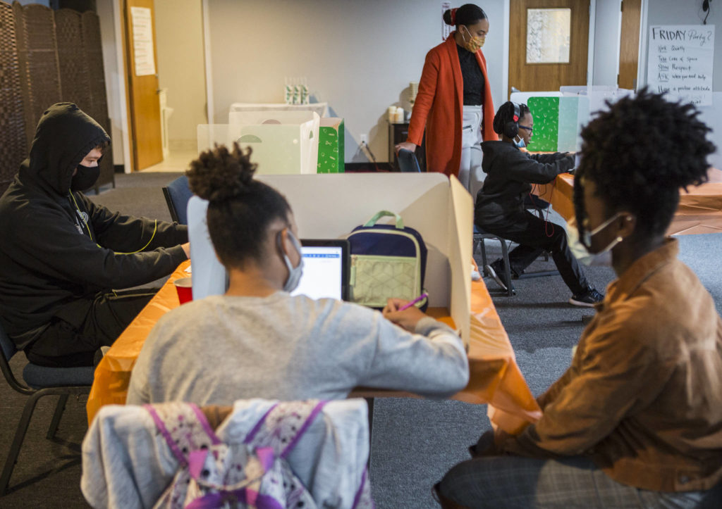Ashley Kiboigo checks on a student at the Safe Haven WiFi Cafe in Everett. (Olivia Vanni / The Herald) 

