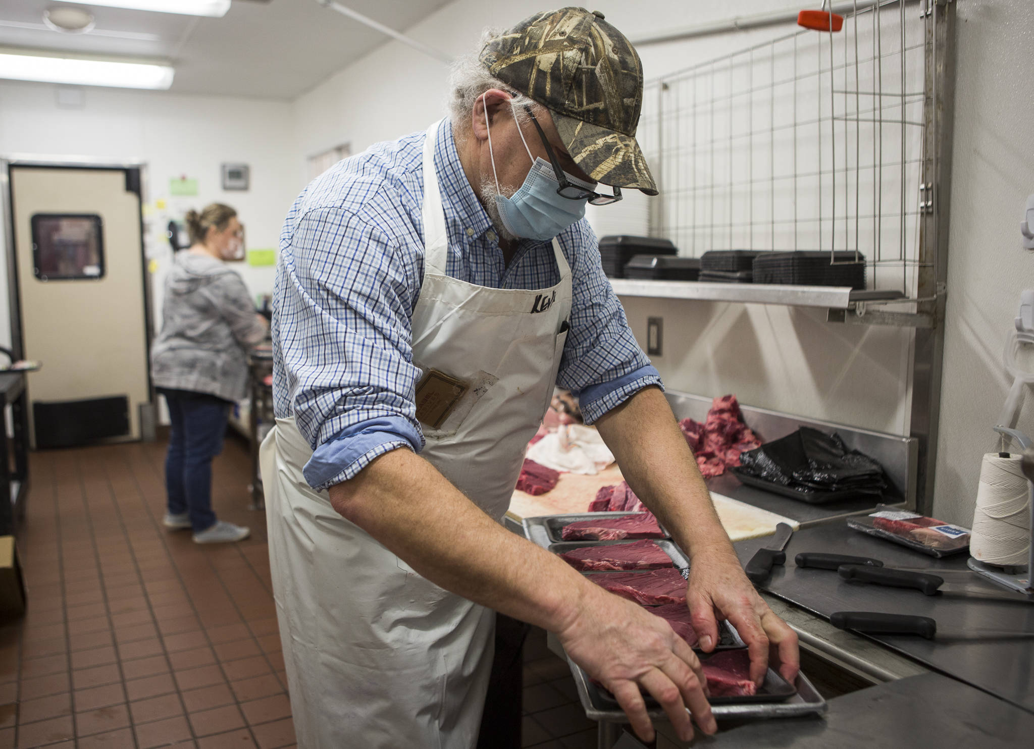 Kevin Ashe (right) and his daughter, Carly Nations, prep meat before opening time at the IGA in Darrington. (Olivia Vanni / The Herald)