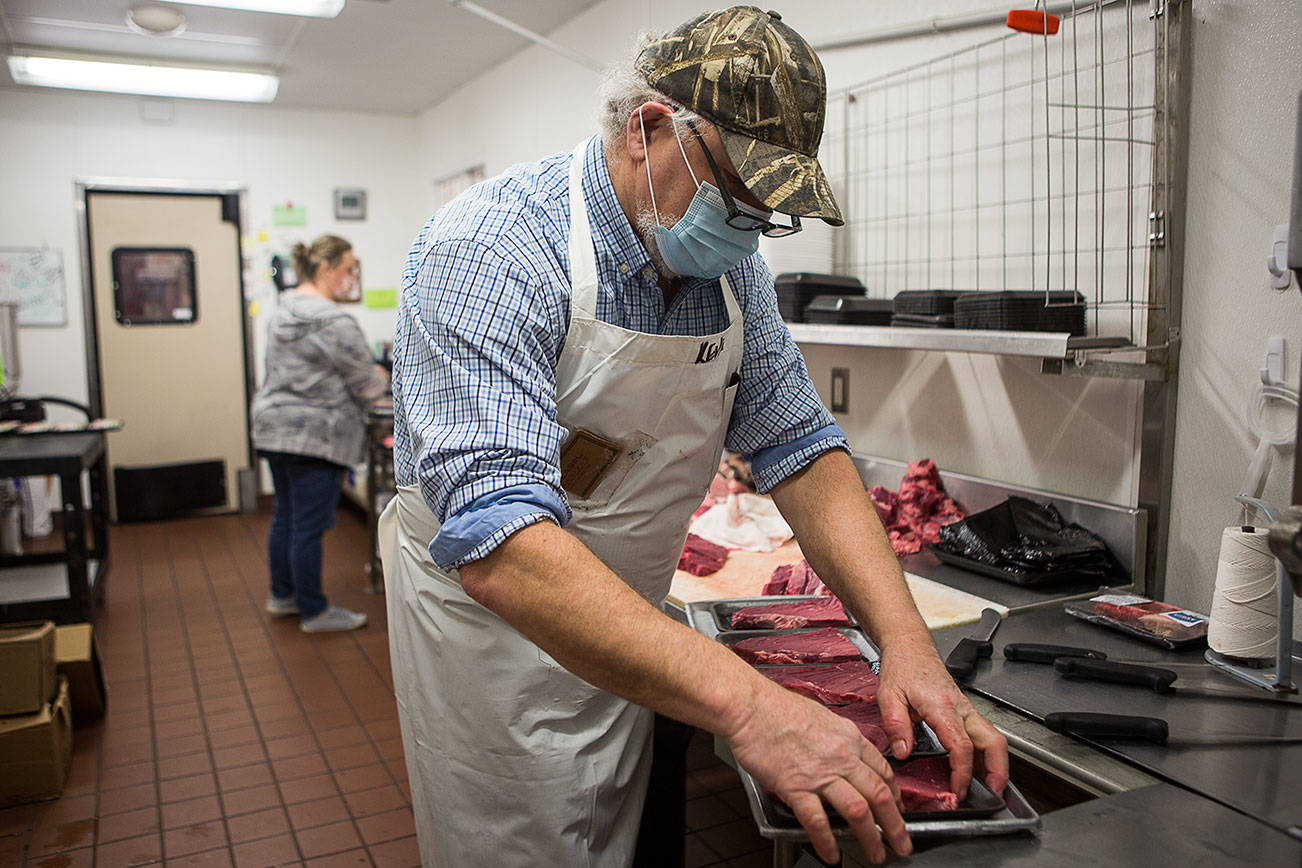 Kevin Ashe, right, and his daughter Carly Nations prep meat before opening on Wednesday, March 3, 2021 in Darrington, Wa. (Olivia Vanni / The Herald)