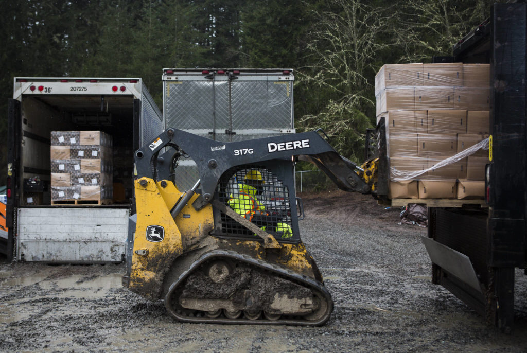 Farmer Frog staff loads food boxes into the back of a truck Friday in Woodinville. (Olivia Vanni / The Herald)
