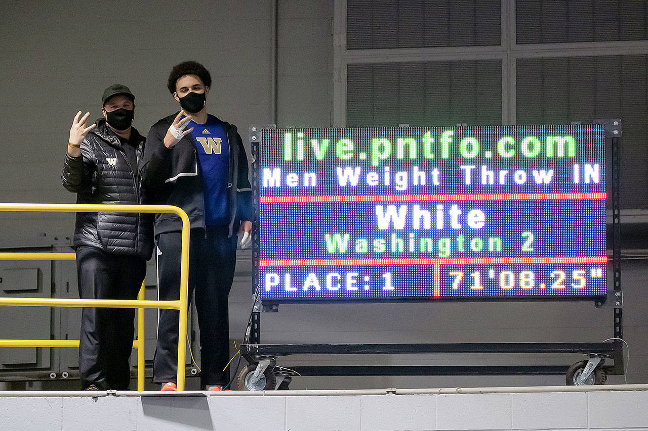 Everett High School graduate Jayden White (right), a University of Washington freshman, poses next to throws coach Andrew Ninow after breaking the Huskies’ school record in the men’s weight throw last Friday. (Photo by Jamie Mitchell)