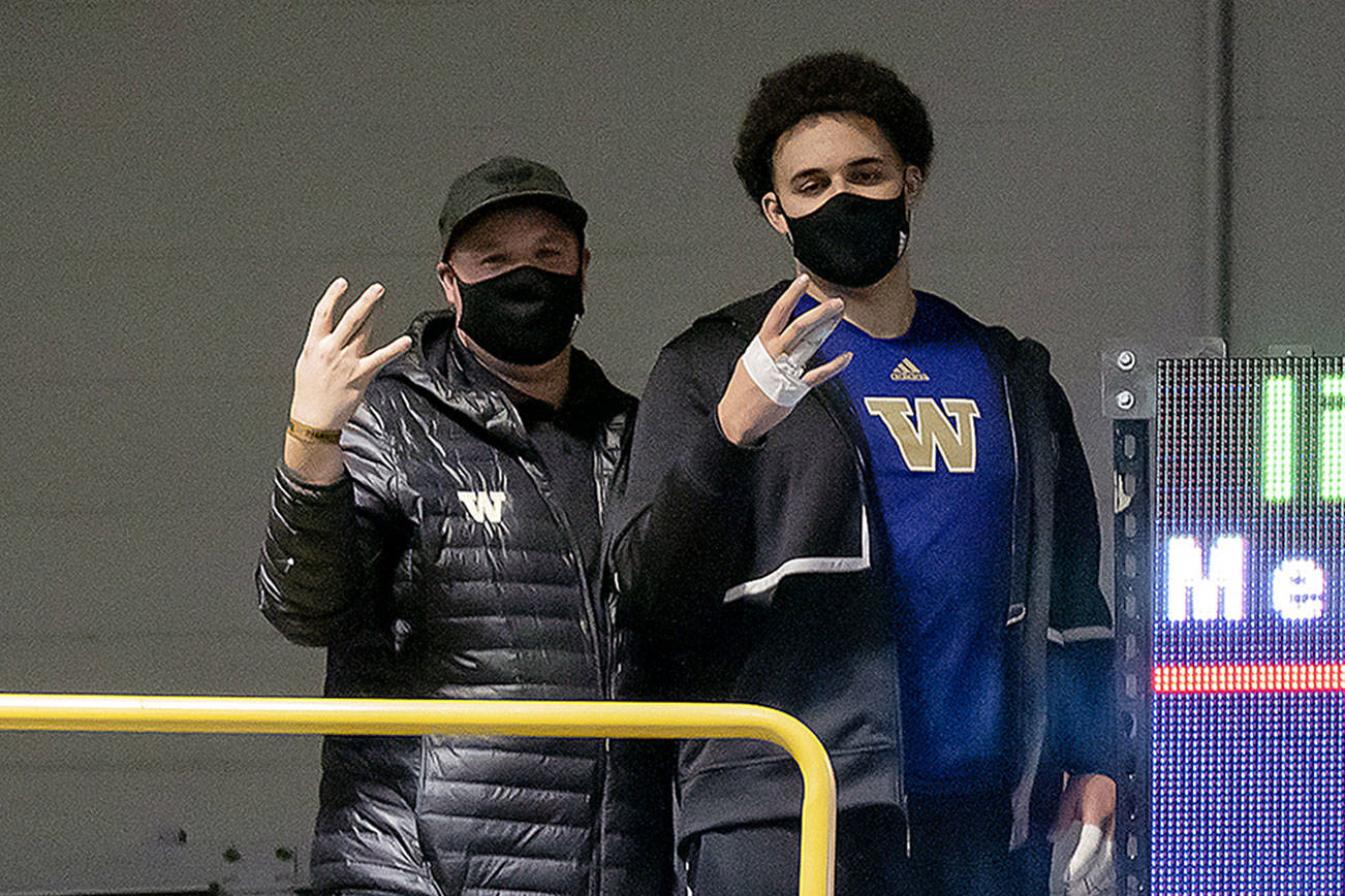 Everett High School graduate Jayden White (right), a University of Washington freshman, poses next to throws coach Andrew Ninow after breaking the Huskies' school record in the weight throw last Friday. (Photo by Jamie Mitchell)