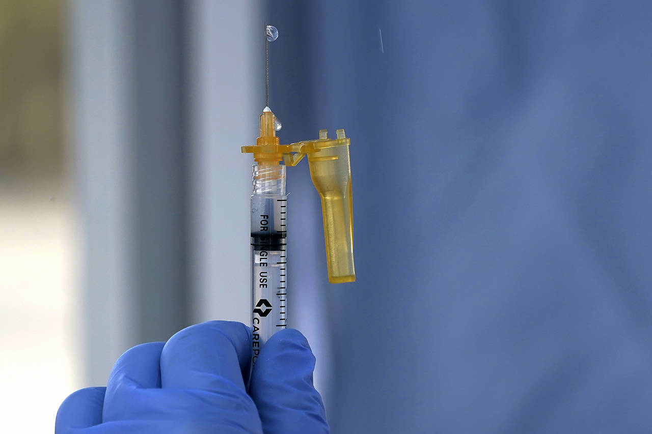 A syringe of the Moderna COVID-19 vaccine is shown Thursday at a drive-up mass vaccination site in Puyallup. (AP Photo/Ted S. Warren)