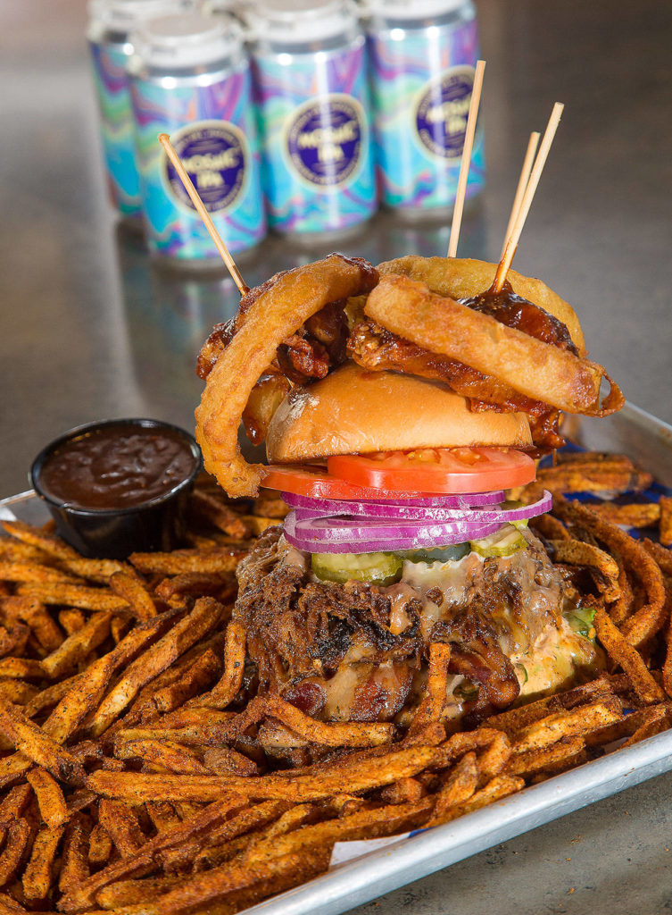 Scuttlebutt Brewing Co. chef Jeremiah Marleau created the Triple Threat burger, made of two patties, pulled pork, three onion rings and a lot of heat. If you can eat it in 25 minutes, it’s on the house. (Andy Bronson / The Herald)
