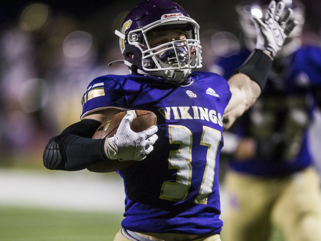 Lake Stevens’ Jay Roughton raises his arms as he runs in for one of his three touchdowns. (Olivia Vanni / The Herald)
