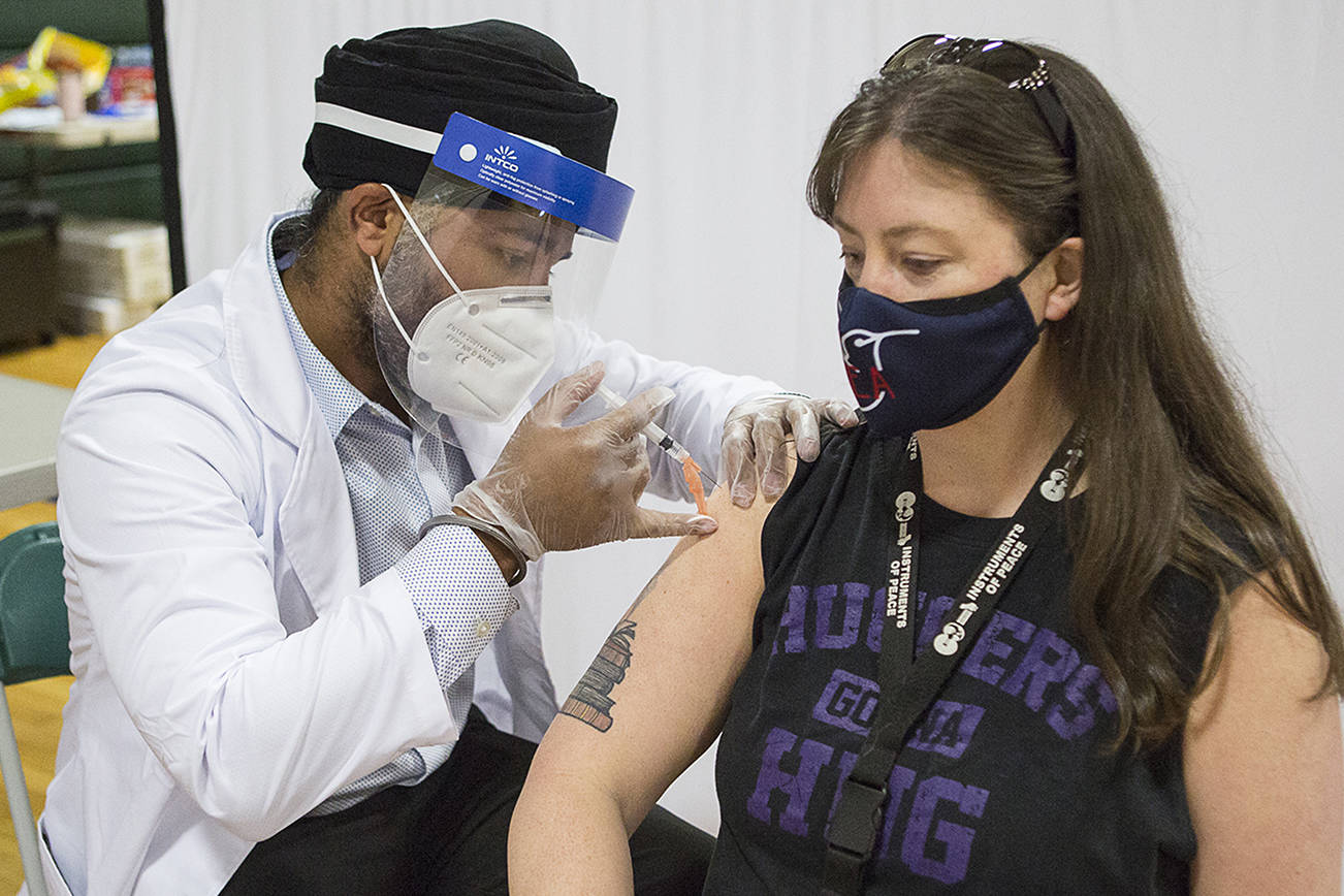 Alaina Livingston, a 4th grade teacher at Silver Furs Elementary, receives her Johnson & Johnson COVID-19 vaccine at a vaccination clinic for Everett School District teachers and staff at Evergreen Middle School on Saturday, March 6, 2021 in Everett, Wa. (Olivia Vanni / The Herald)