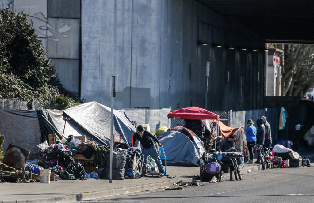 People set up camp along Smith Avenue on Thursday afternoon in Everett. (Kevin Clark / The Herald)
