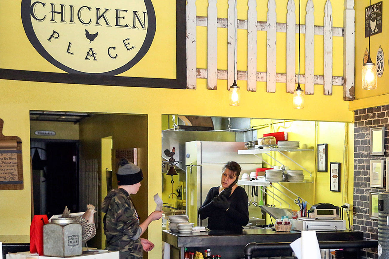 Brandy Wahlstrom, (right) owner-operator of That Chicken Place, along with her son, Zach Maychrak, work Saturday afternoon in Everett on March 14, 2020.  (Kevin Clark / The Herald)