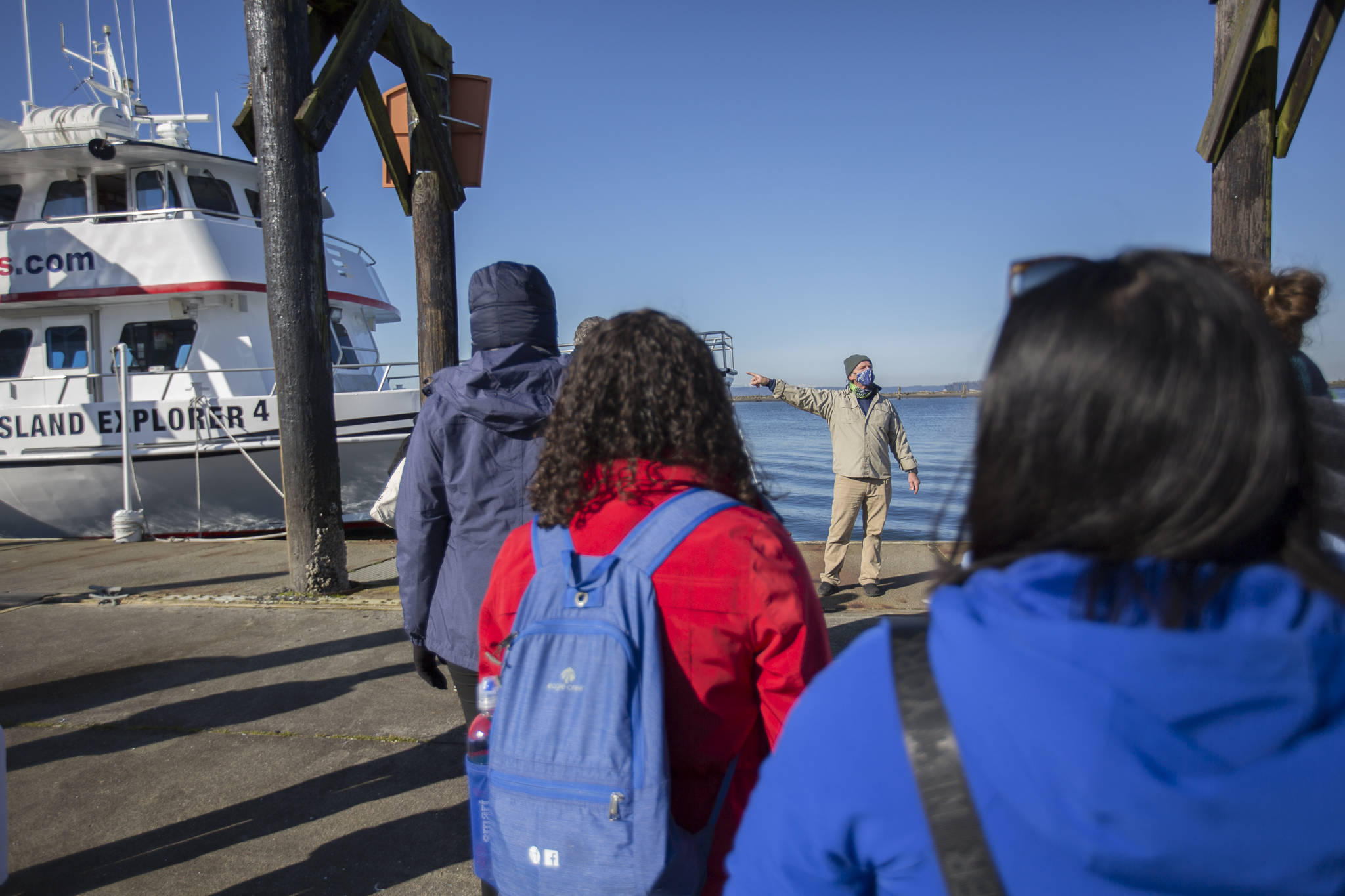 Capt. Carl Williams speaks to a socially distanced and masked group of whale watchers before boarding the Island Explorer 4 in Everett. (Olivia Vanni / The Herald)