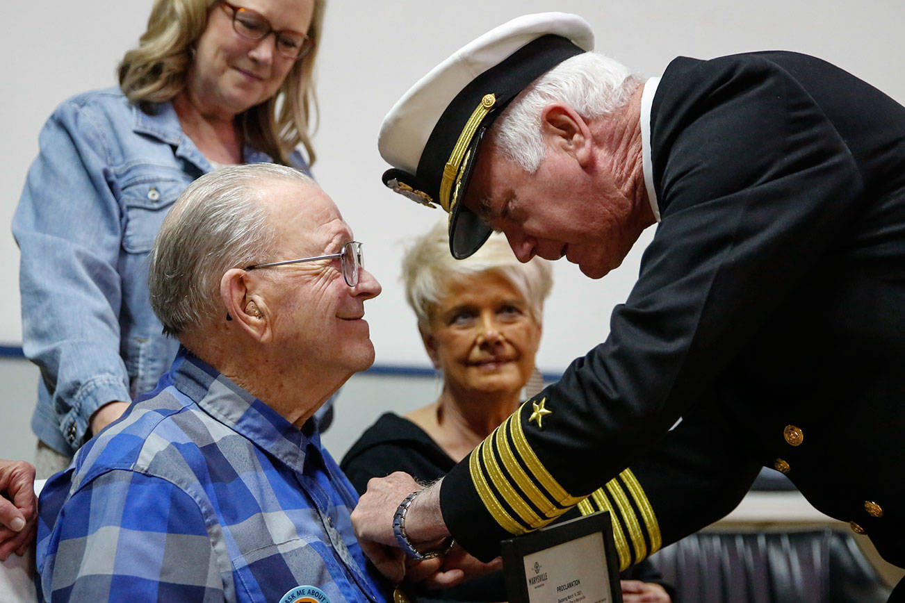 Douglas Roulstone pins a World War II Victory Medal on Bob Peterson, a 93-year-old Navy veteran, with his daughters Cheri Peterson (left) and Susie Schmidt Sunday afternoon at the VFW in Everett on March 14, 2021. (Kevin Clark / The Herald)