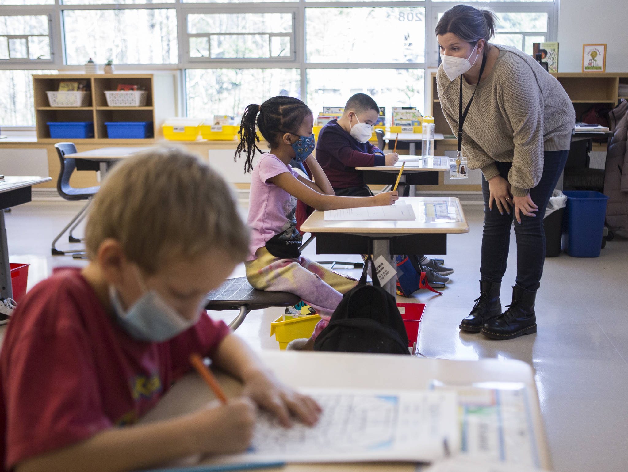 Jessica Cain (right) answers a question about an assignment for Solyana Makele during her hybrid second-grade class on Friday in Lynnwood. (Olivia Vanni / The Herald)