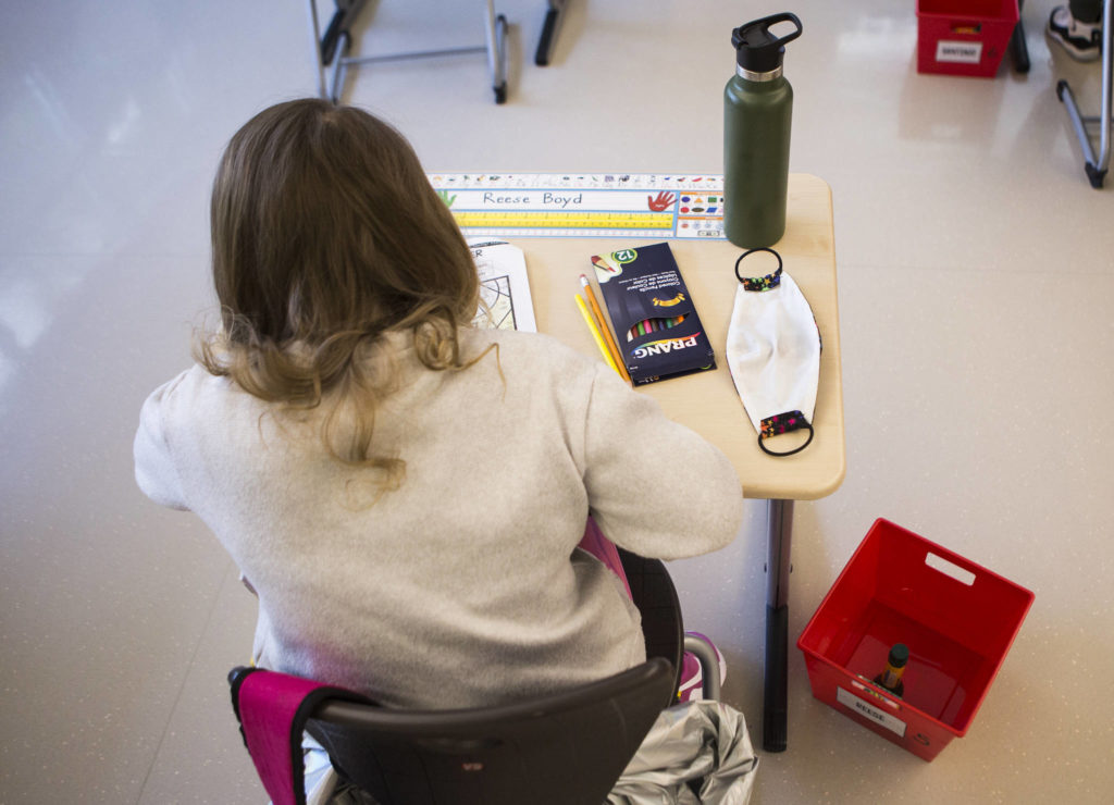 An extra mask sits on a student’s desk at Lake Stickney Elementary on Friday in Lynnwood. (Olivia Vanni / The Herald) 
