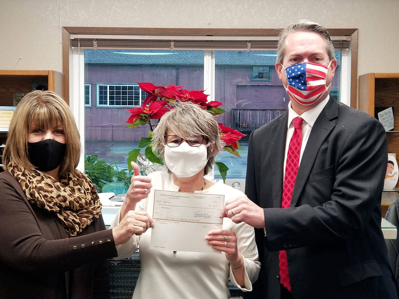 Imagine Museum Director Nancy Johnson accepts a grant of $3600 from Bethany Hopp (left) and Loren Van Loo.
