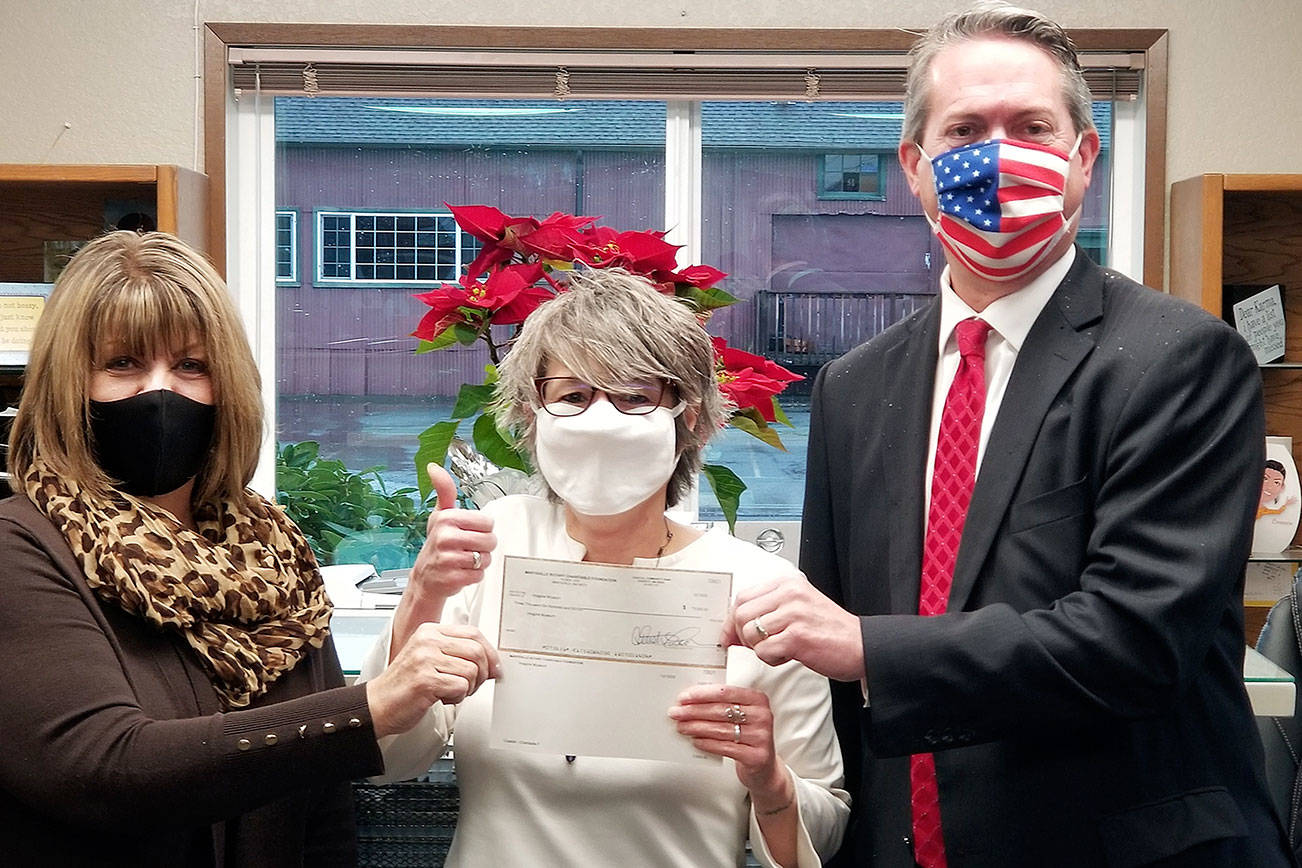 Imagine Museum Director Nancy Johnson accepts a grant of $3600 from Bethany Hopp (left) and Loren Van Loo.