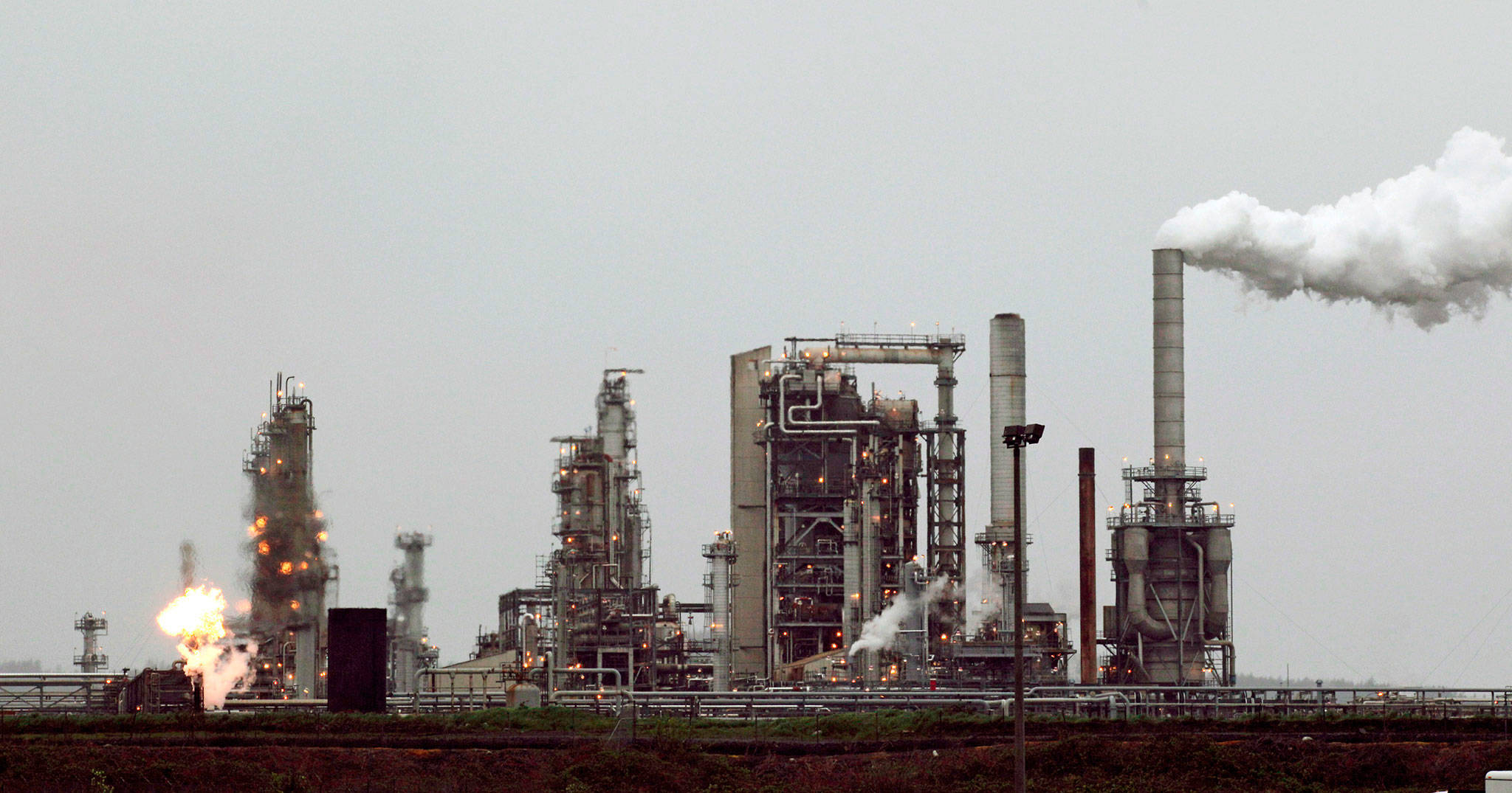 A refinery in Anacortes is shown in 2010, then owned by Andeavor, now Marathon, including a gas flare flame that is part of normal plant operation. (Ted S. Warren / Associated Press file photo)