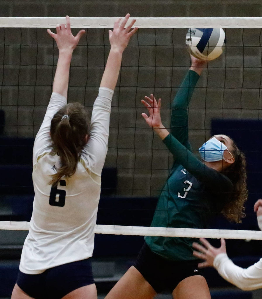 Jackson’s Brooklyn Coleman (right) hits with Arlington’s Malia Shepherd defending Thursday night at Arlington High on March 11, 2021. (Kevin Clark / The Herald)
