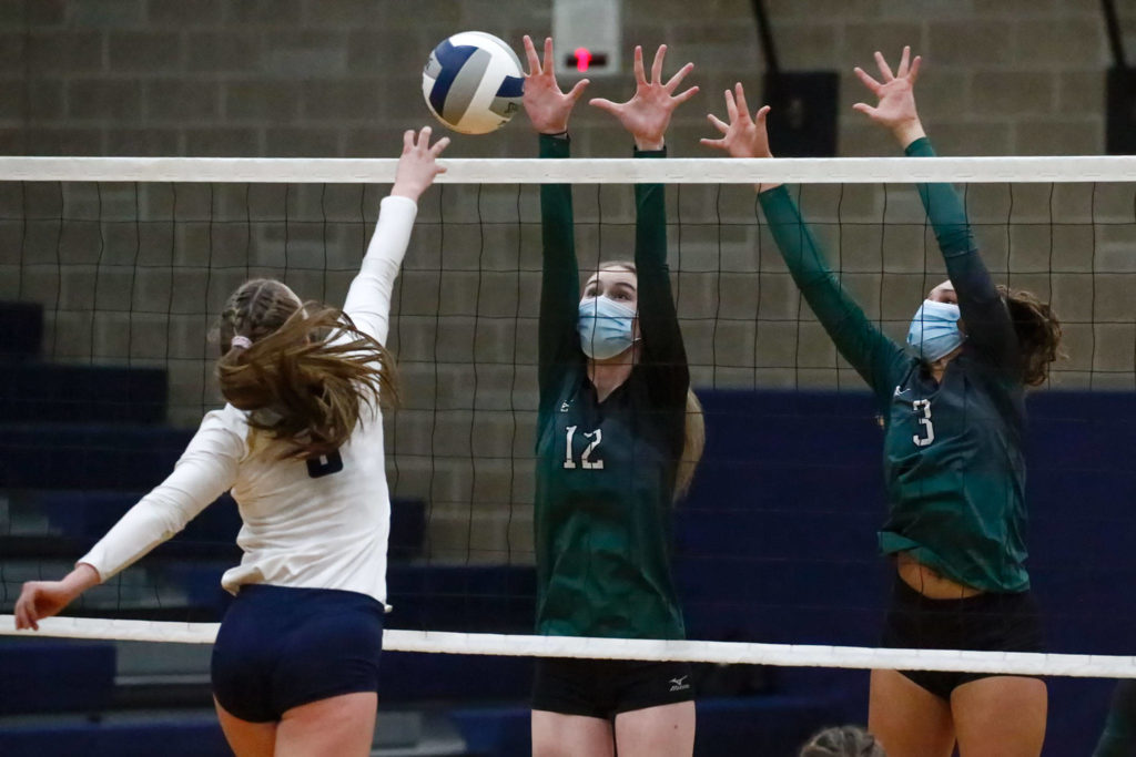 Arlington’s Paige Richards attempts a shot over Jackson’s Olivia Zodrow and Brooklyn ColemanThursday night at Arlington High on March 11, 2021. (Kevin Clark / The Herald)
