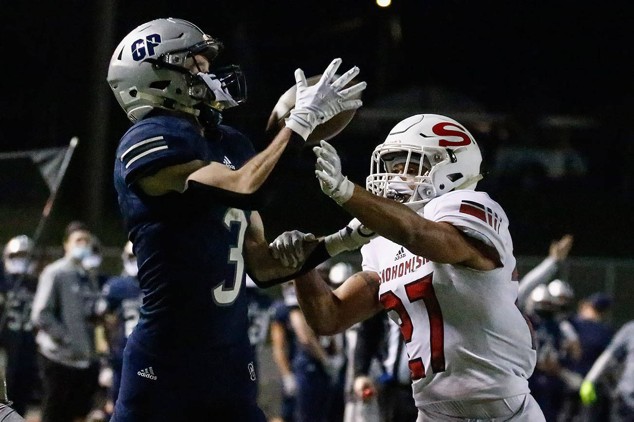 Glacier Peak's Ashton Olson makes a touchdown reception with Snohomish's Makai Williams defending at Veterans Memorial Stadium Friday night in Snohomish on March 12, 2021. (Kevin Clark / The Herald)