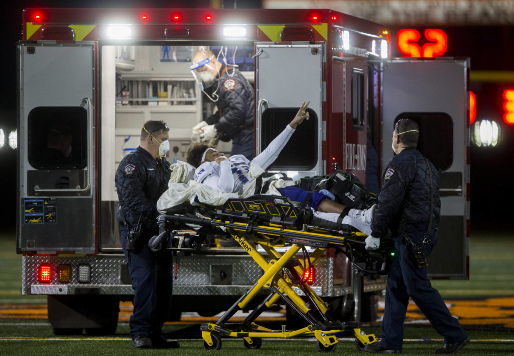 Lake Stevens’ Darquise Oleson puts up a peace sign to his team after suffering a leg injury during the third quarter of the game against Monroe on Friday, March 12, 2021 in Monroe, Wa. (Olivia Vanni / The Herald)
