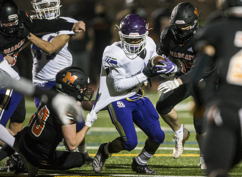 Lake Stevens’ Trayce Hanks runs through a tackle during the game against on Friday, March 12, 2021 in Monroe, Wa. (Olivia Vanni / The Herald)
