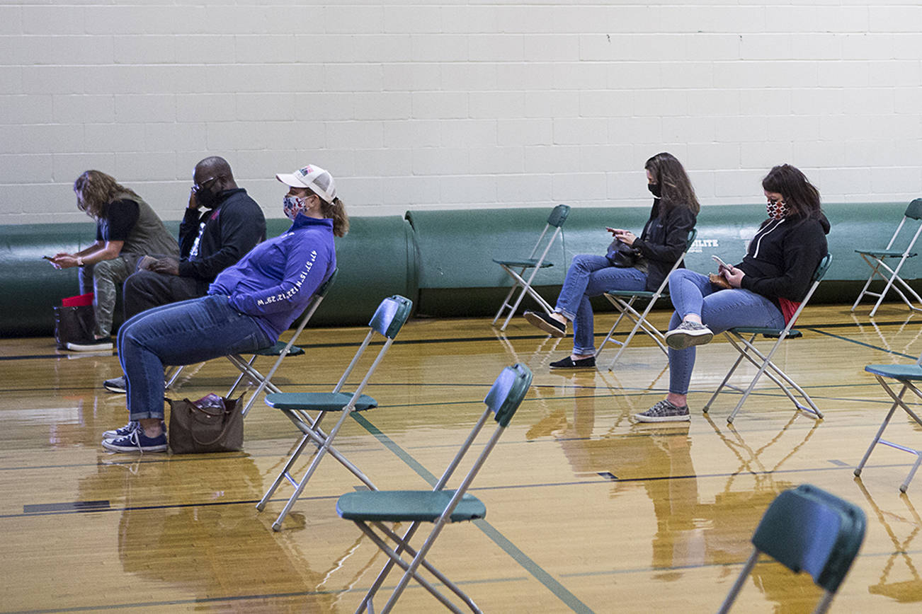 Everett School District teachers and staff that have been vaccinated wait for 15 minutes in the gym at Evergreen Middle School before leaving on Saturday, March 6, 2021 in Everett, Wa. (Olivia Vanni / The Herald)