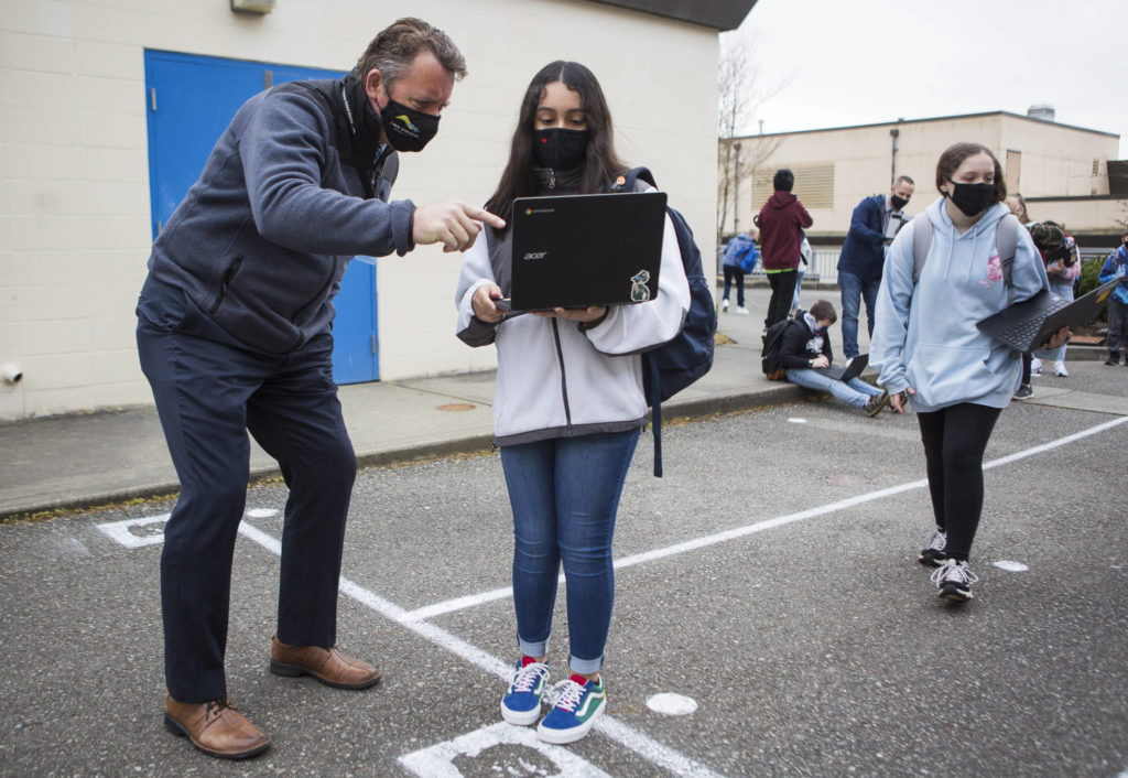 Lake Stevens School District superintendent Ken Collins checks a student’s computer for a completed health questionnaire Tuesday at North Lake Middle School. (Olivia Vanni / The Herald)
