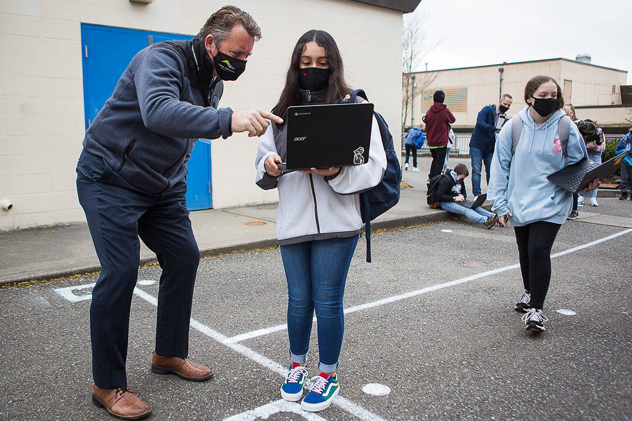 Lake Stevens School District superintendent Ken Collins checks a students computer for a completed health questionnaire at North Lake Middle School on Tuesday, March 23, 2021 in Lake Stevens, Wa. (Olivia Vanni / The Herald)