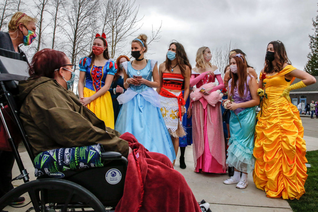 Bethany Erickson (left) is greeted by members of the Lake Stevens High School volleyball team during a fundraiser at Lundeen Park in Lake Stevens on March 6. (Kevin Clark / The Herald)
