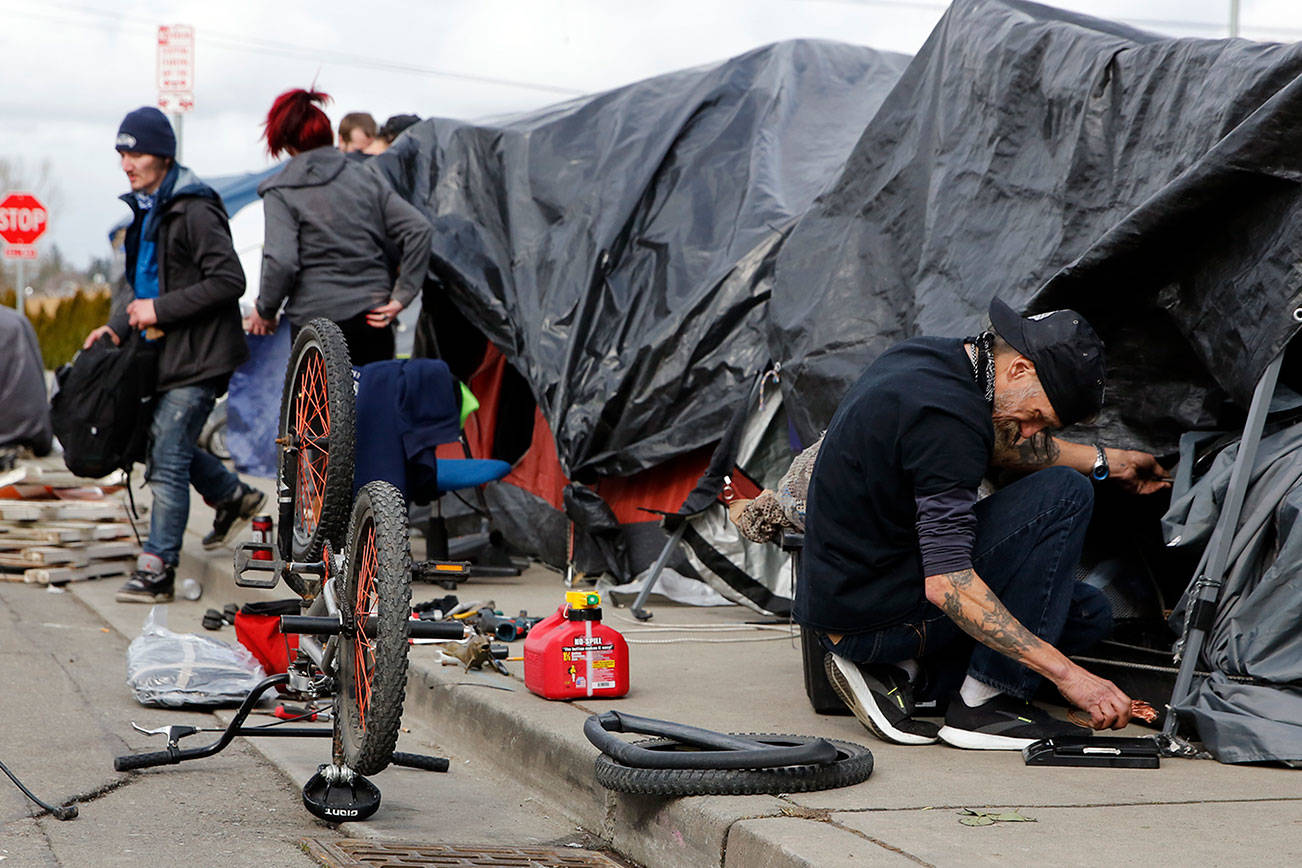 People experiencing homelessness along Smith Avenue would need to find a new area to live if the Everett City Council passes a no-sit, no-lie ordinance. (Kevin Clark / The Herald)