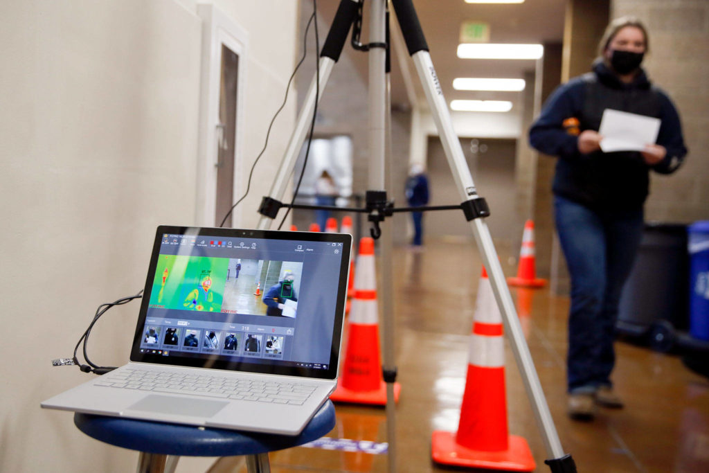 A freshman get a thermal image scan Friday morning at Arlington High School. (Kevin Clark / The Herald)
