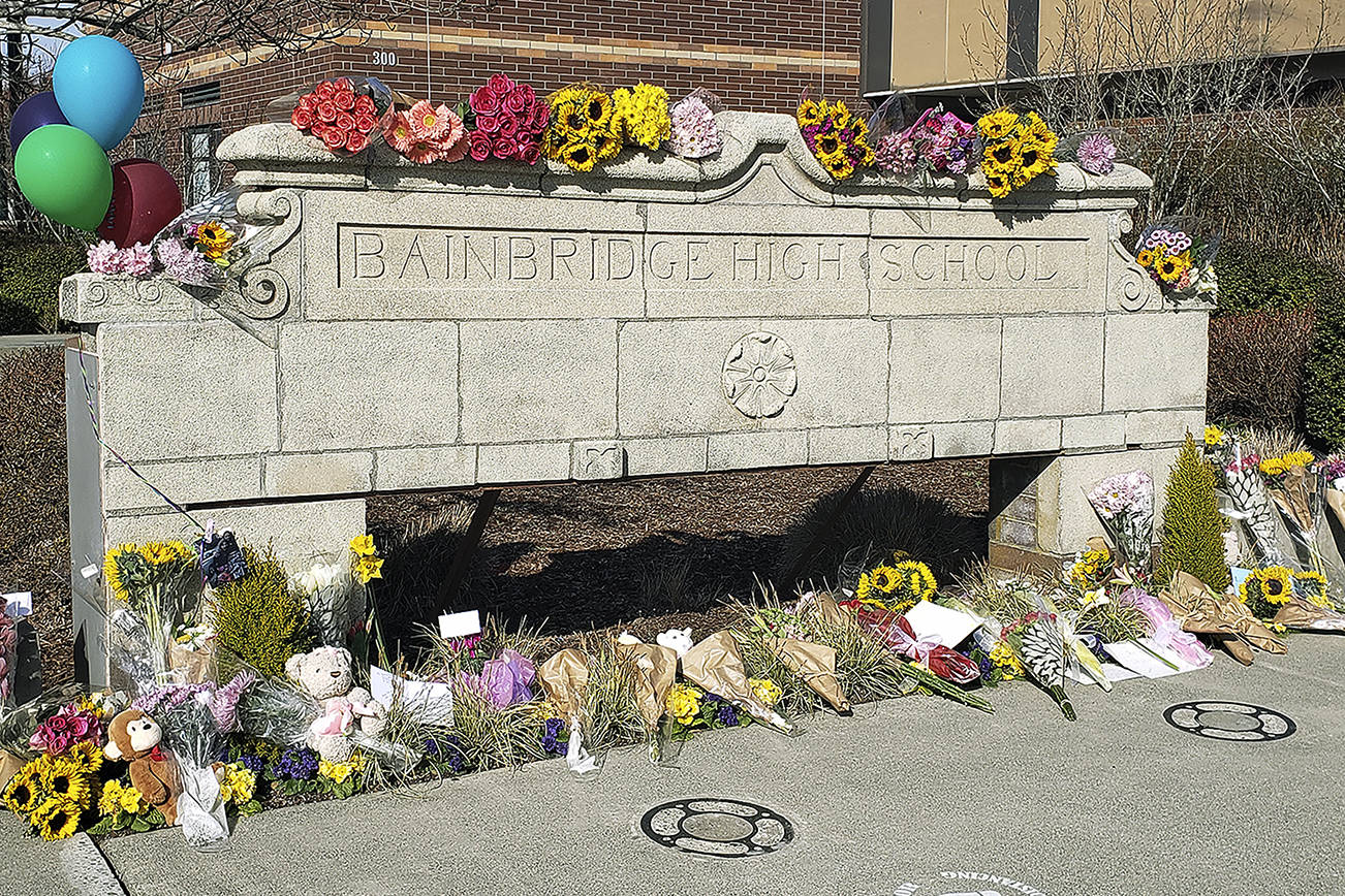 Flowers and other items were placed at the front of Bainbridge High School Wednesday to honor the three students who were killed in a single-vehicle rollover Tuesday. Tyler Shuey/Bainbridge Island Review