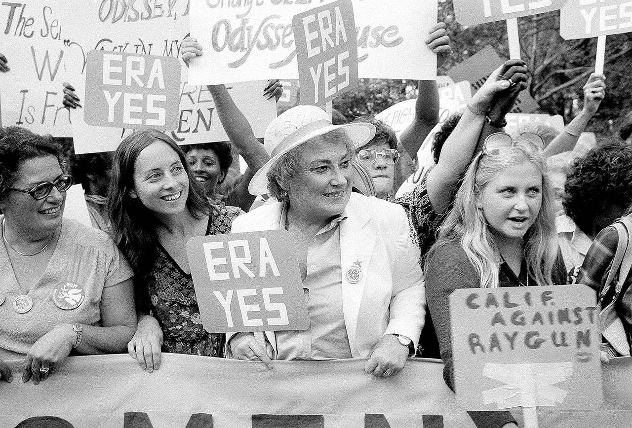 Bella Abzug (center with hat) smiles as she holds up her ERA sign in a pro-equal rights demonstration on New York’s Fifth Avenue on Aug. 26, 1980. (Associated Press file photo)