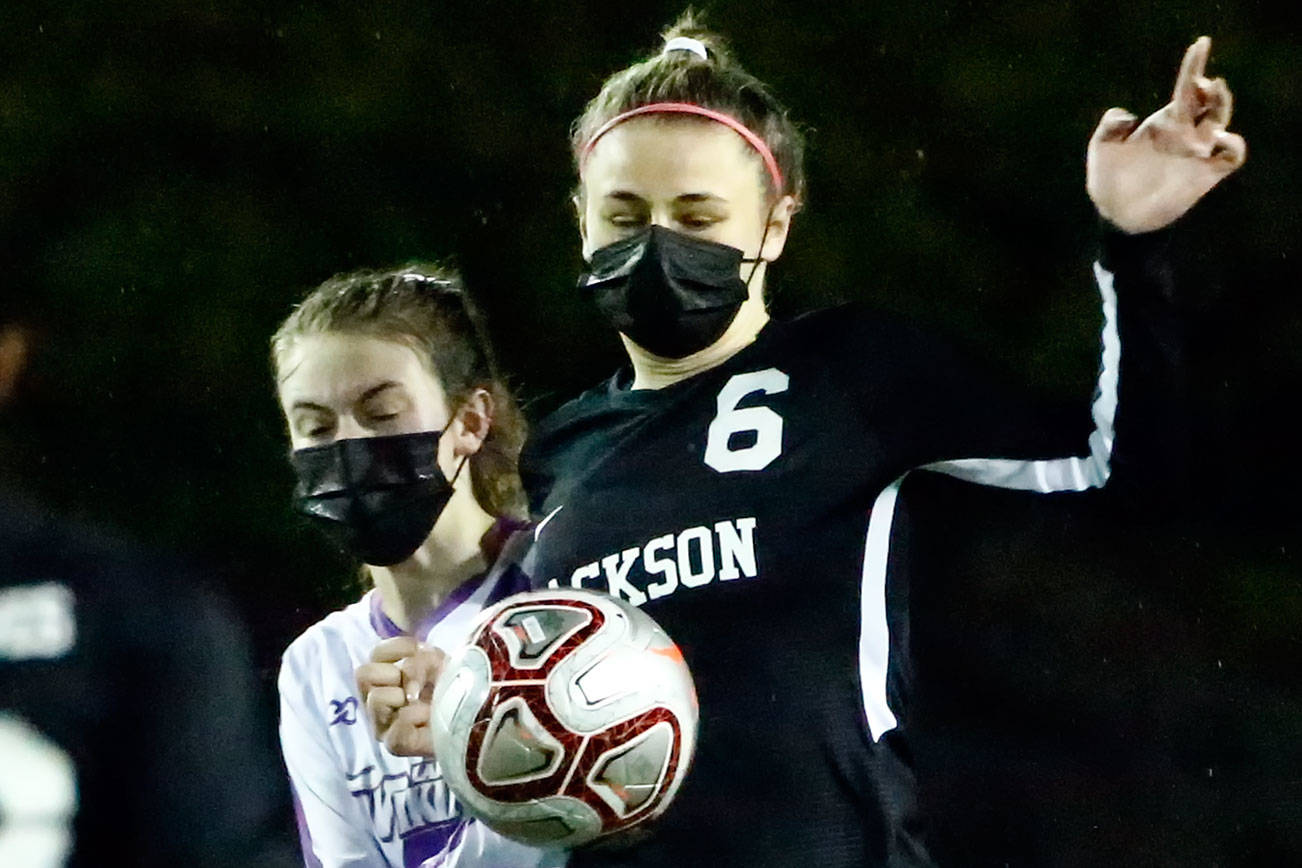 Jackson's Abigail McKay controls the ball with Lake Stevens' Delaine Polly trailing Thursday night at Memorial Stadium in Everett on March 18, 2021. (Kevin Clark / The Herald)