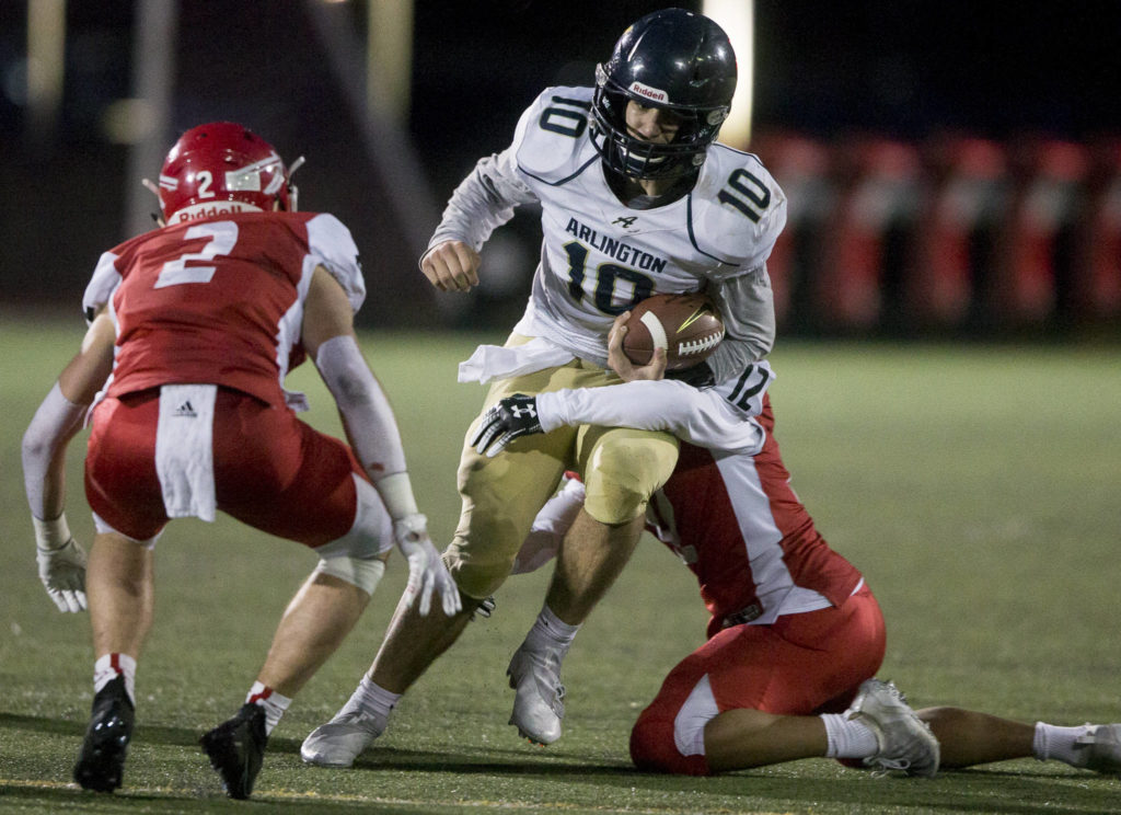 Arlington’s Michael Tsoukalas is tackled during the game on Friday, March 19, 2021 in Marysville, Wa. (Olivia Vanni / The Herald)
