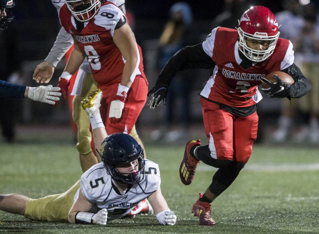 Marysville-Pilchuck’s Gaylen Gray escapes a tackle by Arlington’s Luke Brown during the game on Friday, March 19, 2021 in Marysville, Wa. (Olivia Vanni / The Herald)
