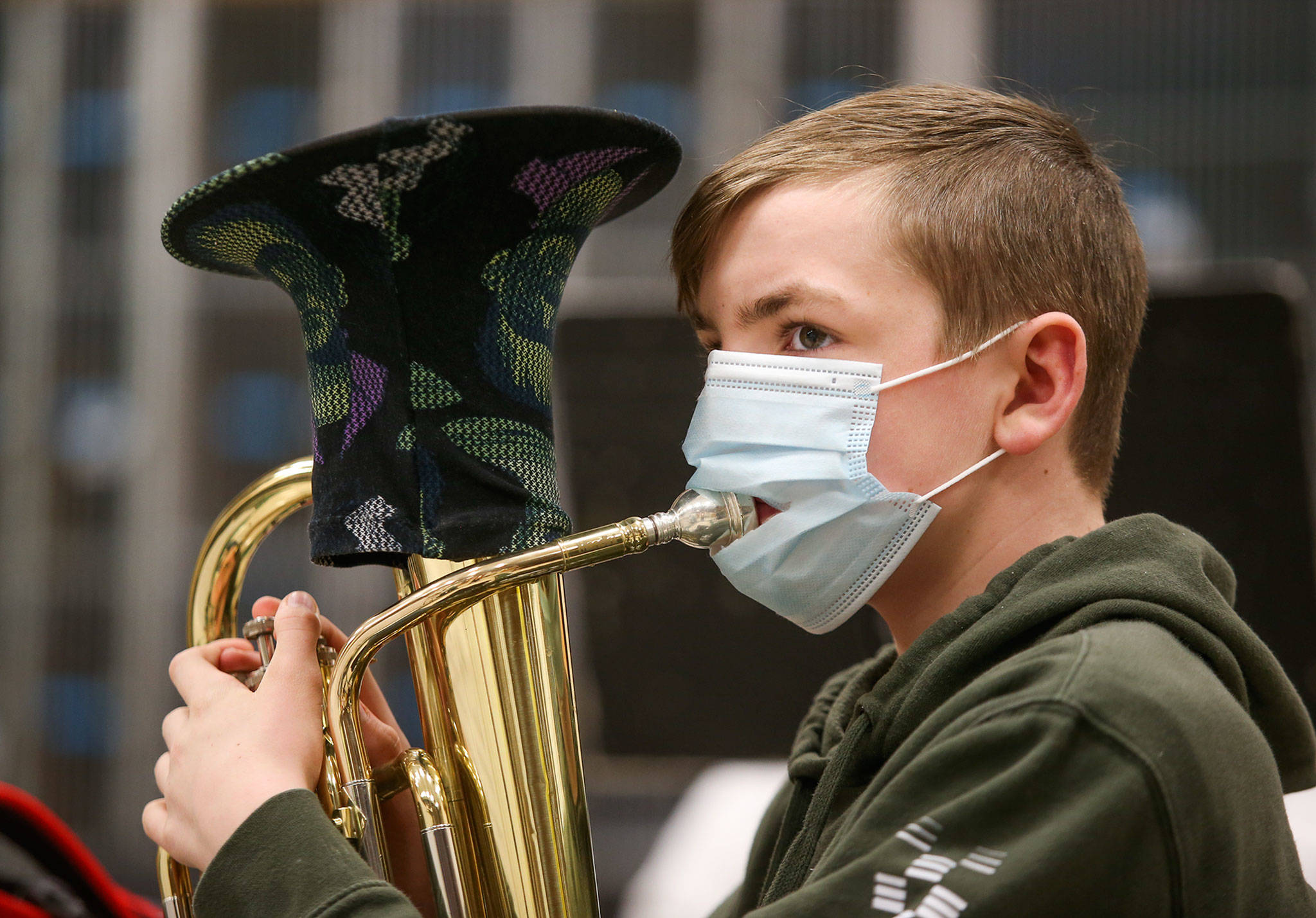Shaun Metz wears a mask with a slit in it so he can play the baritone Thursday during Haller Middle School band practice in Arlington. (Andy Bronson / The Herald)