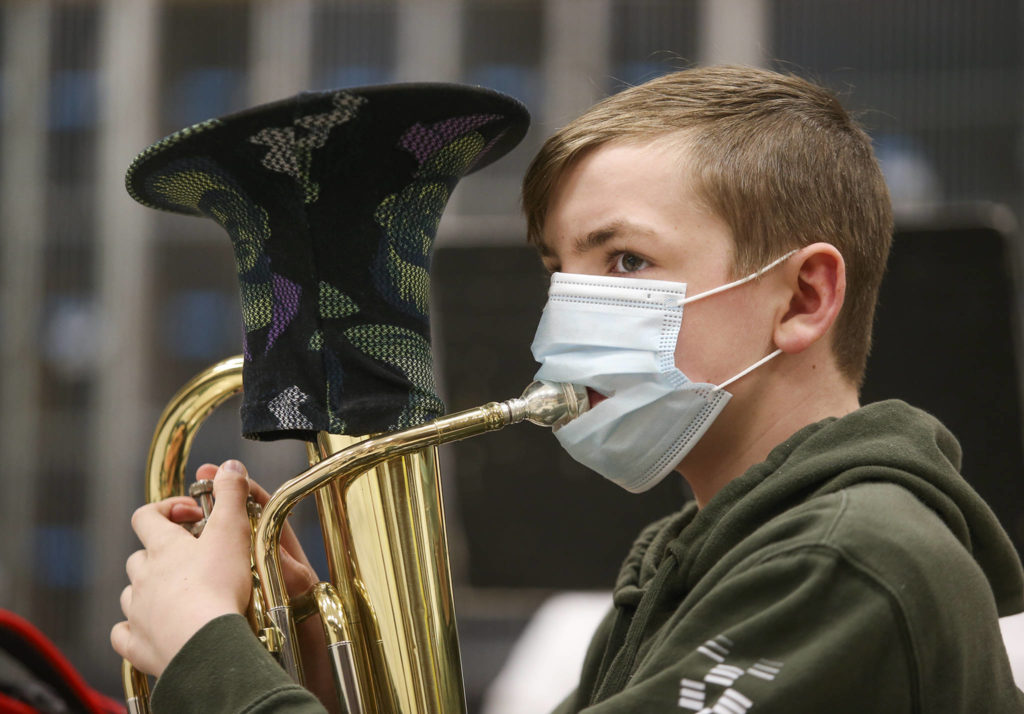 Shaun Metz wears a mask with a slit in it so he can play the baritone Thursday during Haller Middle School band practice in Arlington. (Andy Bronson / The Herald)
