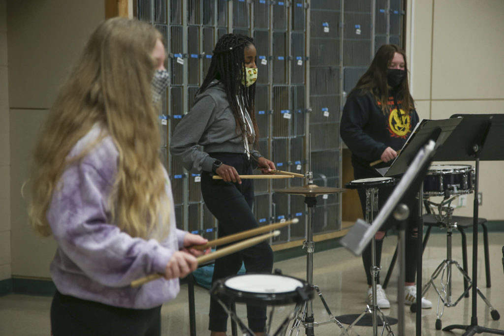 The percussion section — Grace Lish, Aleah Barnett, and Danica Jensen — plays instruments with social distance spacing during Haller Middle School band practice Thursday in Arlington. (Andy Bronson / The Herald)
