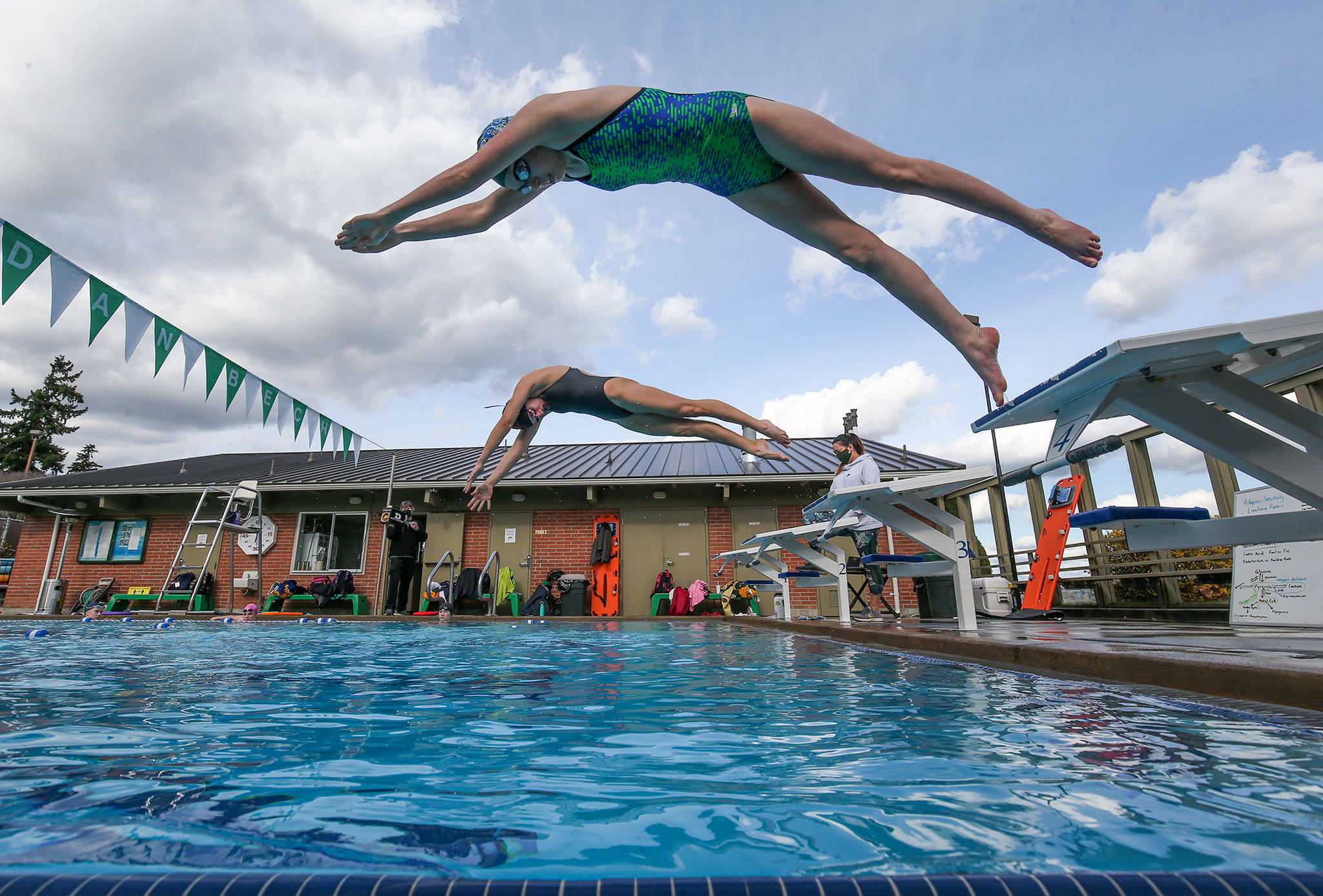 Shorecrest’s Mia Sanchez (top) and Elle Howson take off from the blocks as the girls swim team practices at a four-lane outdoor pool at Sheridan Beach Community Club on Tuesday in Lake Forest Park. The Shoreline Pool closed down when COVID hit and left the Shoreline School District without an indoor facility to practice at. (Andy Bronson / The Herald)