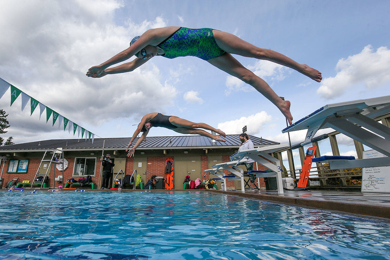 Shorecrest’s Mia Sanchez, top, and Elle Howson take off from the blocks as the girls swim team practices at a four-lane outdoor pool at Sheridan Beach Community Club on Tuesday in Lake Forest Park . The Shoreline Pool closed down when COVID hit and left the Shoreline School District without an indoor facility to practice at. (Andy Bronson / The Herald)