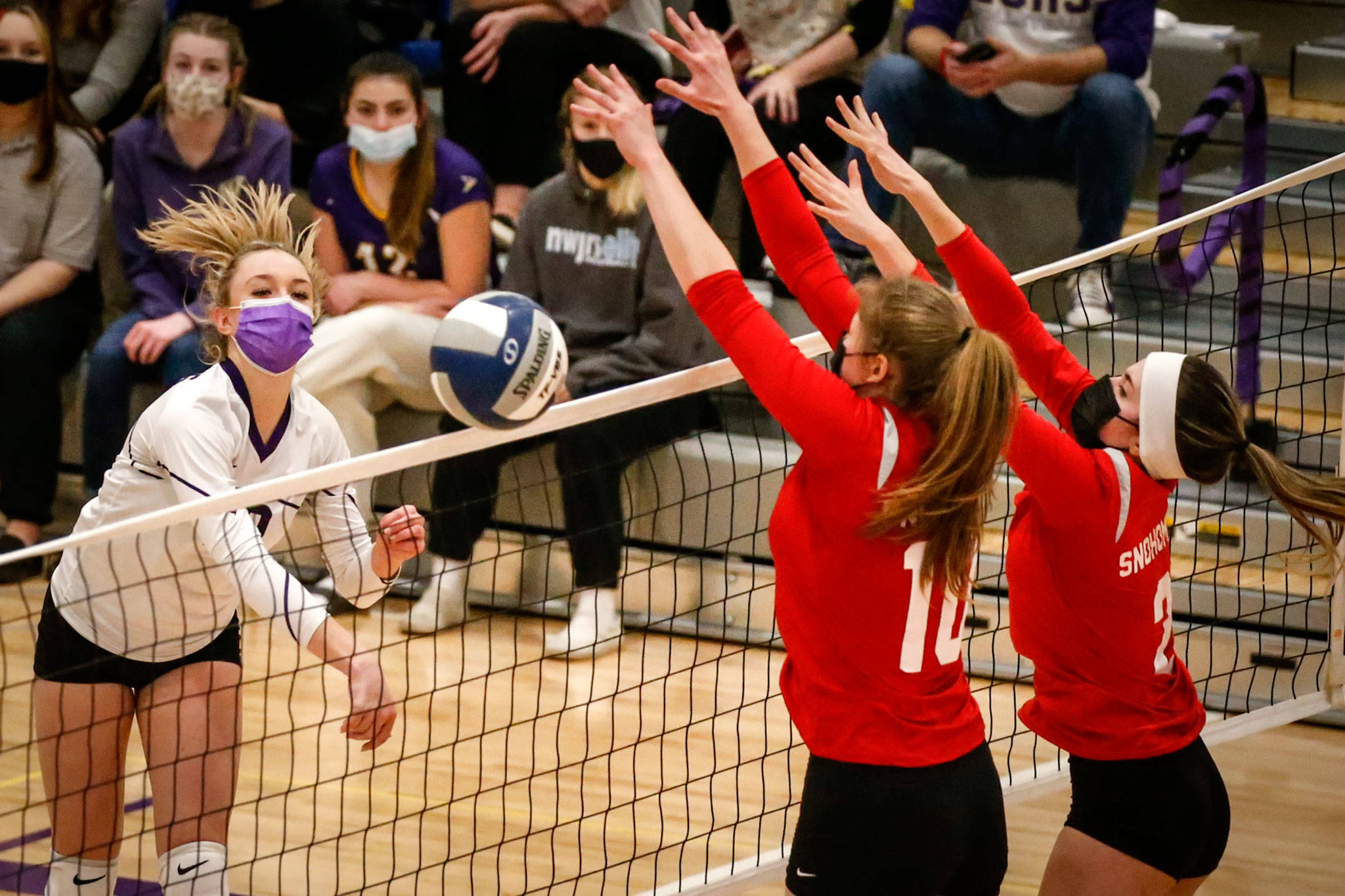 Lake Stevens’ Tatum Smith (left) attempts a kill with Snohomish’s Sarah Campfield (10) and Ayla Grant (right) defending during a match Thursday night at Lake Stevens High School. (Kevin Clark / The Herald)
