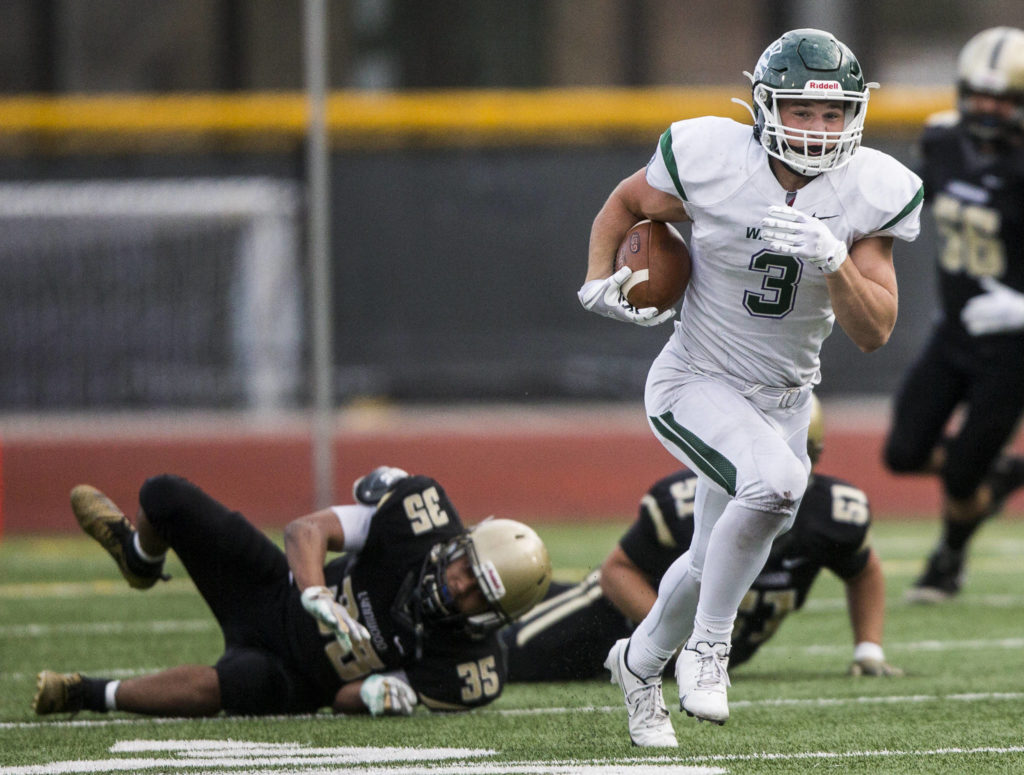 Edmonds-Woodway’s Ryan Fahey escapes multiple tackles to run the ball down the field during a game against Lynnwood on Friday in Edmonds. (Olivia Vanni / The Herald)
