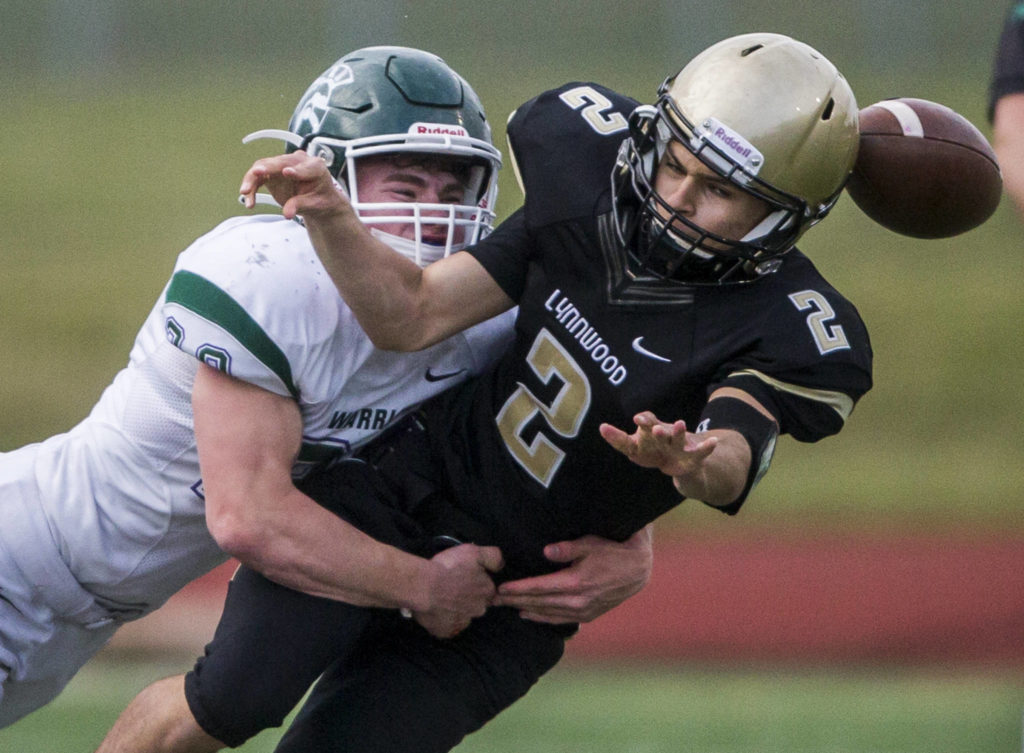Edmonds-Woodway’s Jake Ingram sacks Lynnwood quarterback Julius Heudorf forcing a fumble during the game on Friday, March 26, 2021 in Edmonds, Wa. (Olivia Vanni / The Herald)
