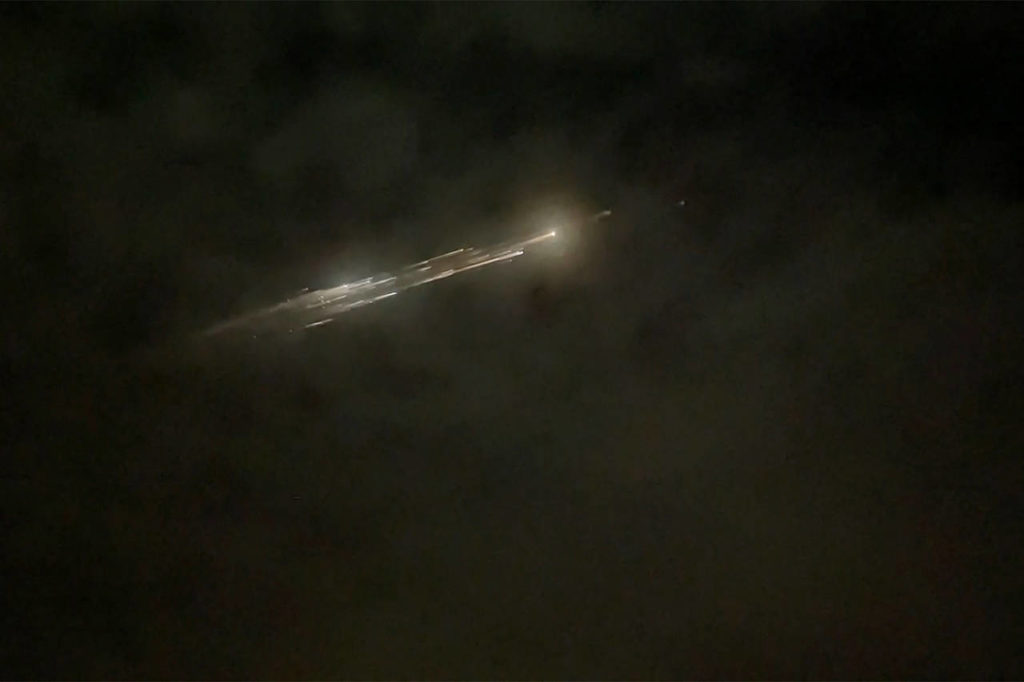 In this image taken from video, debris from a SpaceX rocket lights up the sky behind clouds over Vancouver, Washington, on Thursday evening. (Roman Puzhlyakov via AP)

