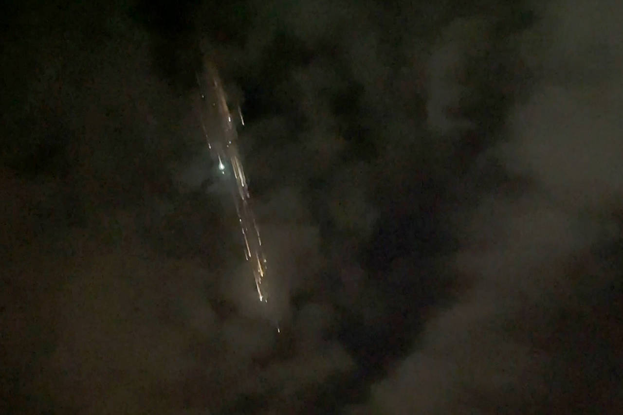 In this image taken from video, debris from a SpaceX rocket lights up the sky behind clouds over Vancouver, Washington, on Thursday evening. (Roman Puzhlyakov via AP)