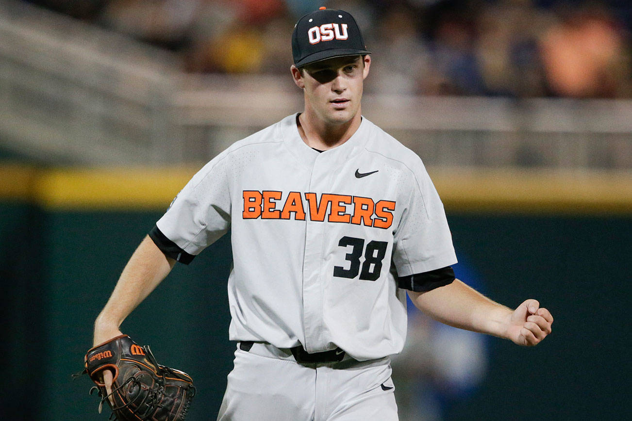 Oregon State closing pitcher Jake Mulholland clenches his fist after the last out of the eighth inning of an NCAA College World Series baseball elimination game against Mississippi State in Omaha, Neb., Saturday, June 23, 2018. (AP Photo/Nati Harnik)