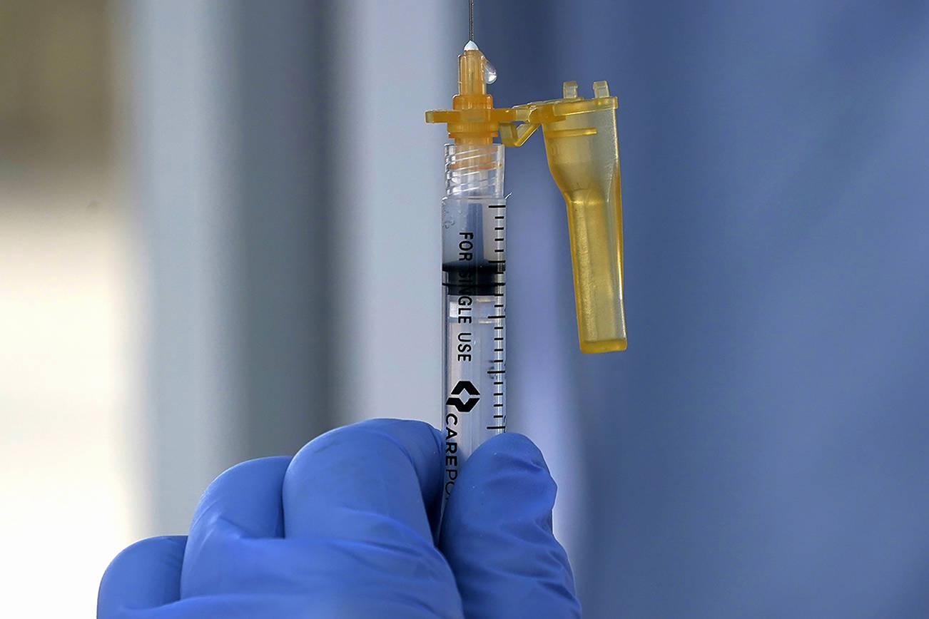 A syringe of the Moderna COVID-19 vaccine is shown Thursday, March 4, 2021, at a drive-up mass vaccination site in Puyallup, Wash., south of Seattle. Officials said they expected to deliver approximately 2500 second doses of the Moderna COVID-19 vaccine at the site Thursday. (AP Photo/Ted S. Warren)